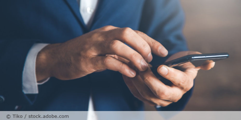 Mann mit Handy in der Hand.