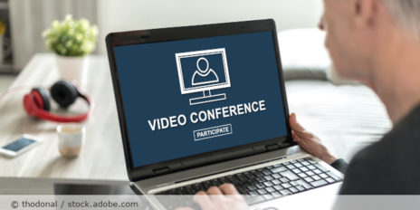 Mann mit Laptop mit einen Fenster zur Videokonferenz auf dem Bildschirm.