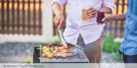 Männer die am Grill stehen.
