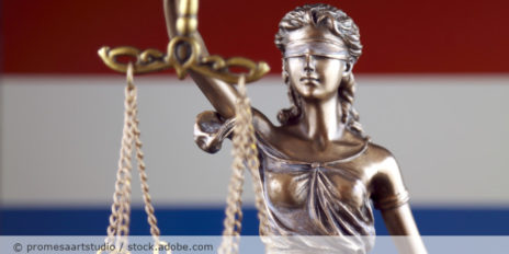 Justicia Figur und die Niederlanden Flagge im Hintergrund.