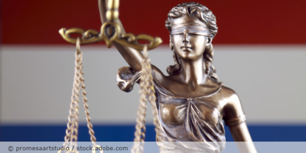 Justicia Figur und die Niederlanden Flagge im Hintergrund.