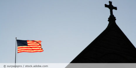 Die USA-Flagge neben einer Kirche.