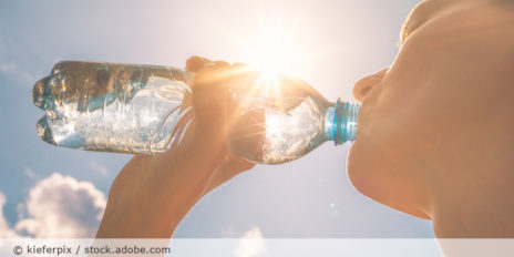Frau trinkt aus einer Wasserflasche.