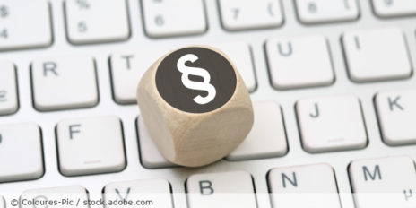 Würfel auf einer Tastatur mit einen Paragraph-Symbol.