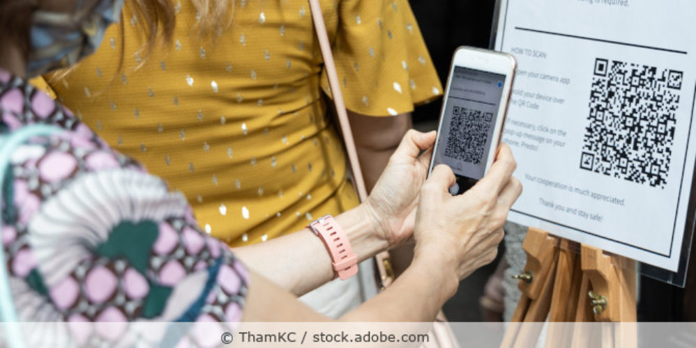Frau scannt einen QR-Code.