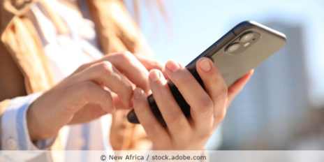 Frau hält ein Handy in der Hand.