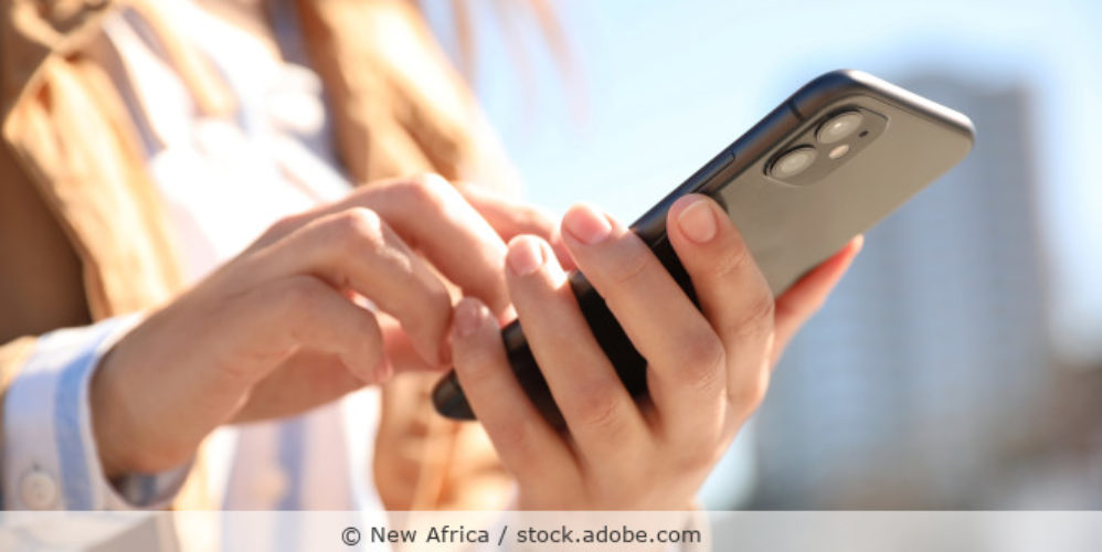 Frau hält ein Handy in der Hand.