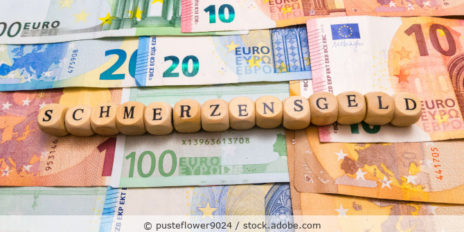 Würfel mit der Aufschrift "SCHMERZENSGELD". Darunter mehrere Geldscheine.