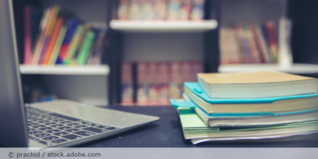 Schreibtisch mit Laptop und Büchern.