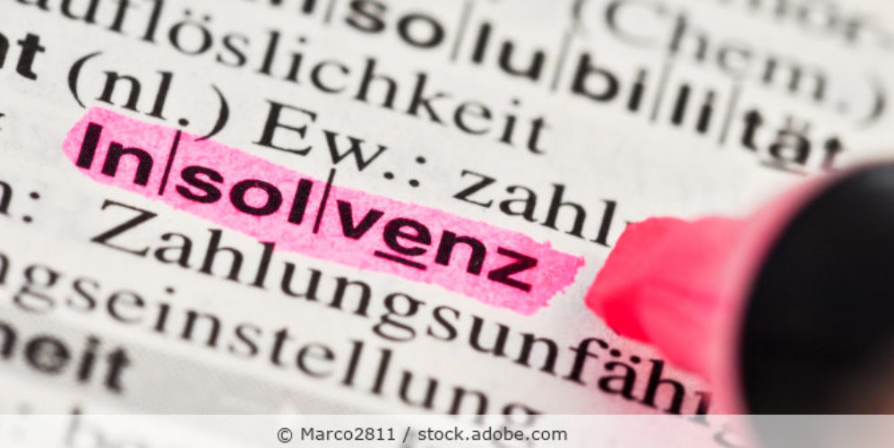 Das Wort Insolvenz mit Textmarker hervorgehoben in einem Buch