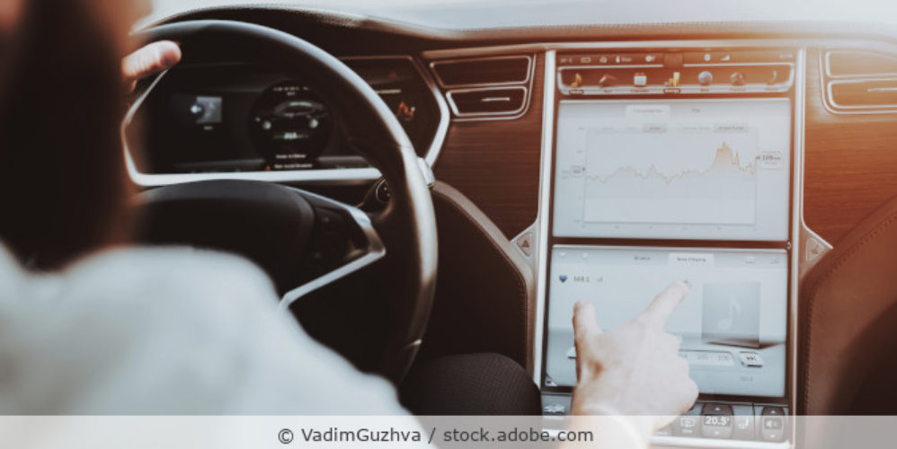 moderner Mann bedient ein großes Display im Auto