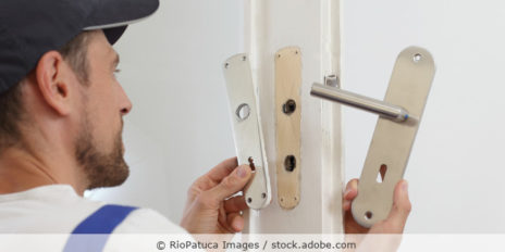 Handwerker wechselt Türgriff