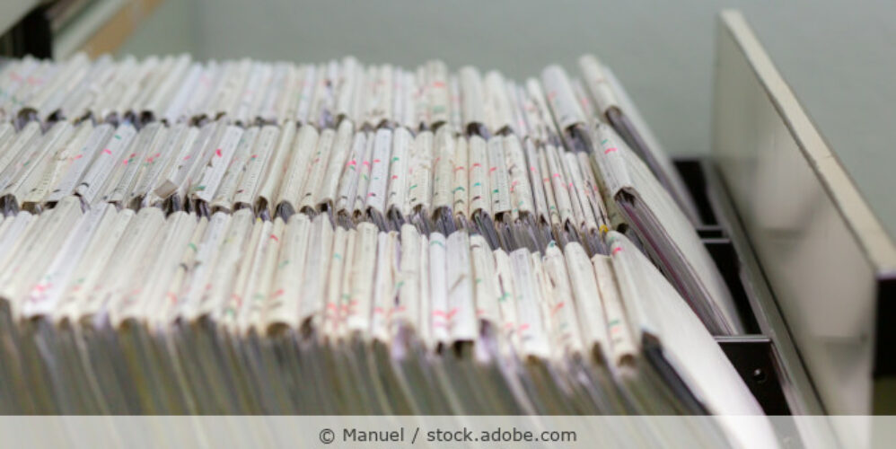 Geöffnete Schrankschublade mit Patientenakten.