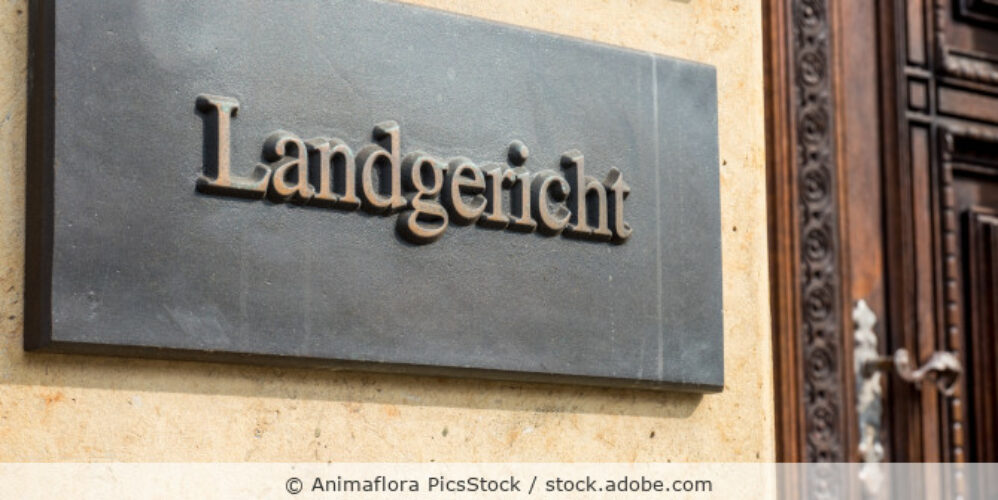 Metallschild mit der Aufschrift Landgericht außen an einem Gebäude.