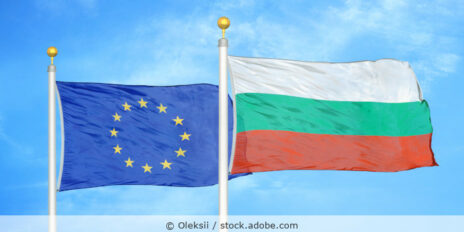 Flaggen der EU und von Bulgarien vor blauem Himmel.