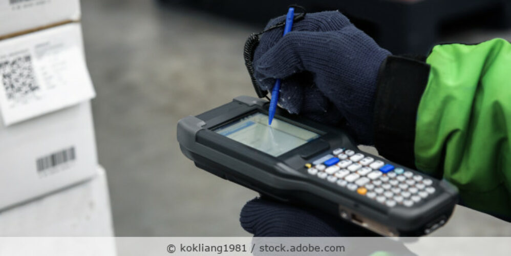 Person arbeitet mit einem Handscanner in der Hand in einem Lager.