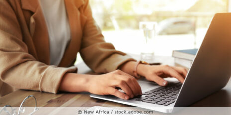 Frau arbeitet am Schreibtisch an ihrem Laptop.
