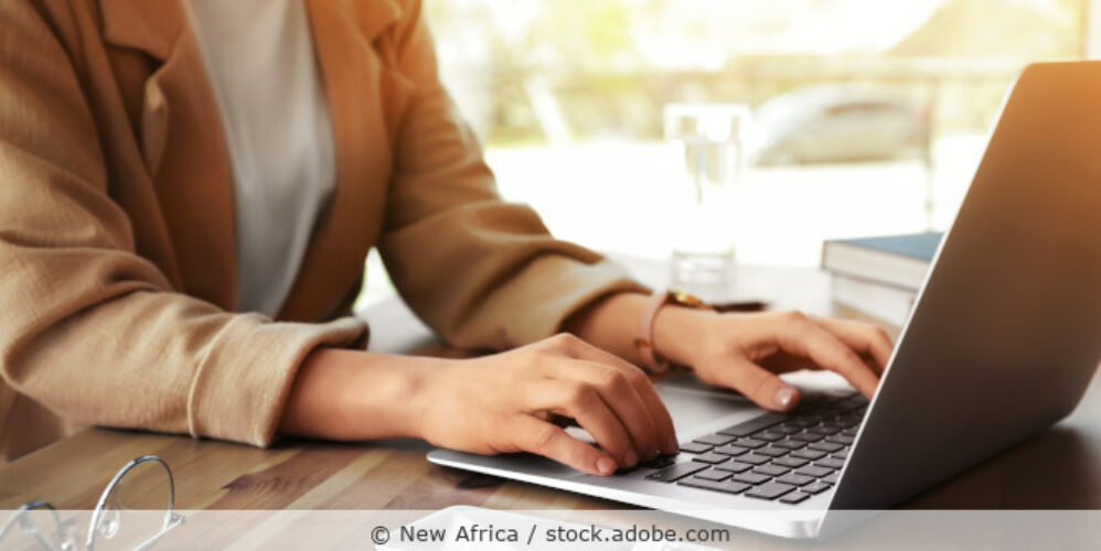 Frau arbeitet am Schreibtisch an ihrem Laptop.