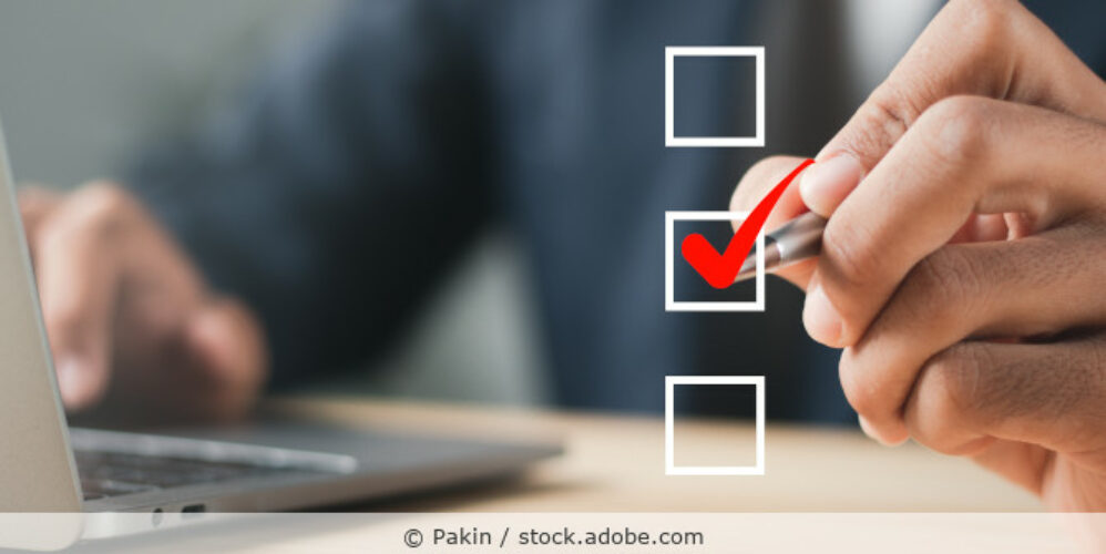 Mann sitzt vor dem Laptop und hakt eine Checkbox ab.