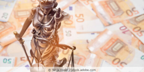 Eine Justitia-Figur steht auf lauter 50-Euro-Geldscheinen.