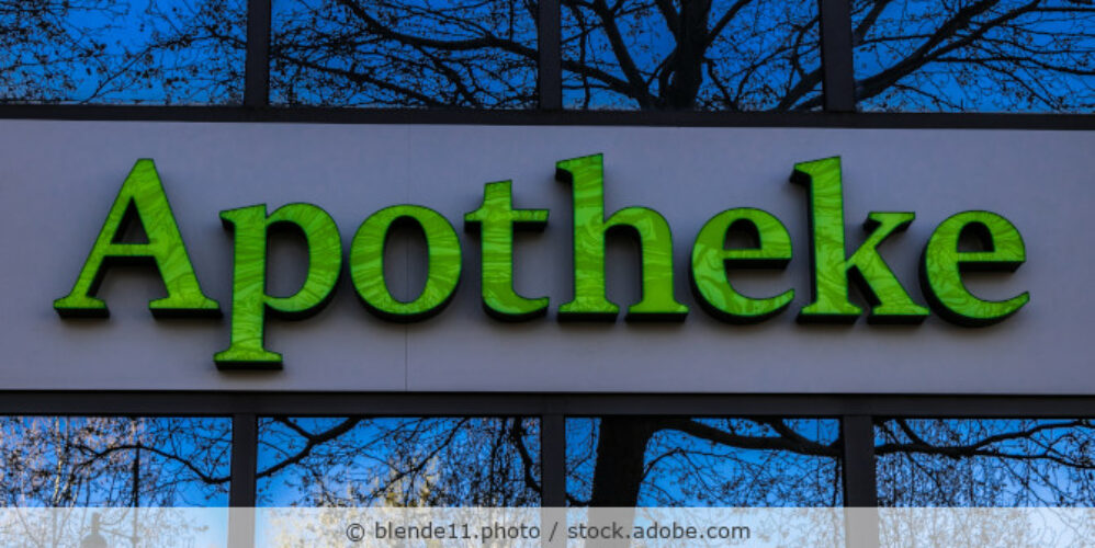 Apothekenschild mit grünen Buchstaben außen an einer Fassade.