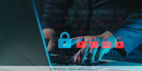 Hacker sitzt vor einem Laptop in einem dunklen Raum. Geöffnete Schlösser als Symbole sind im Vordergrund zu sehen.