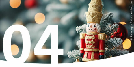 Eine Nussknackerfigur vor Tannengrün als Bild für den 4. Dezember im Adventskalender.