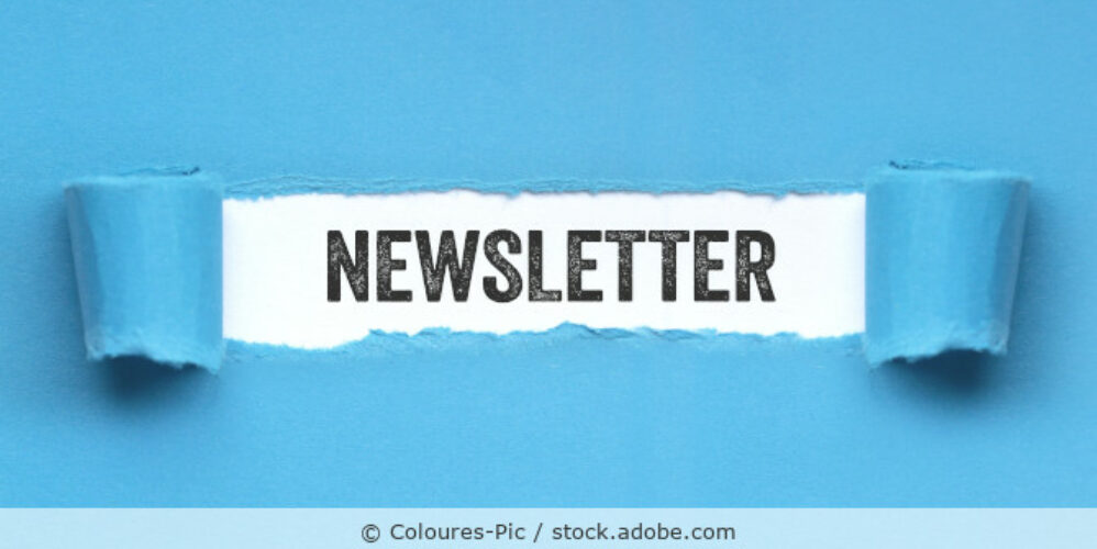 Das Wort Newsletter steht in schwarzer Schrift auf weißen Papier, das unter einem aufgerissenen blauen Papier sichtbar ist.