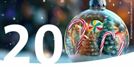 Eine transparente Weihnachtskugel, die Tannen und Zuckerstangen umfasst als Bild für den 20. Dezember im Adventskalender.
