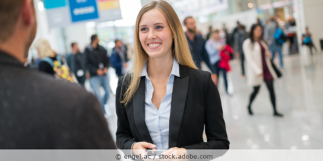Junge Dame im Gespräch auf einer Messe.