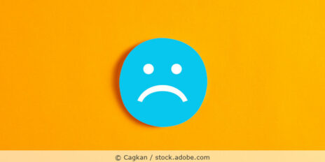 Ein blaues Smiley-Gesicht mit schlechter Laune bzw. trauigem Ausdruck auf orangefarbenem Hintergrund.