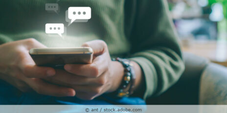 Frau hält ein Handy und tipp eine Nachricht, über dem Handy sind Icons für Chatnachrichten als Illustration zu sehen.