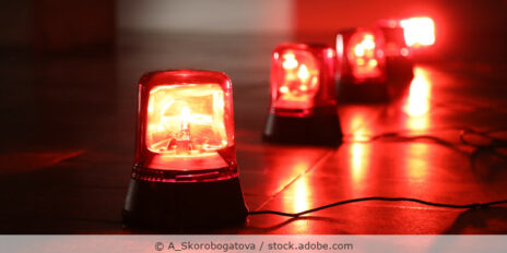 Rote Alarmlichter stehen in einer Reihe auf dem Boden.