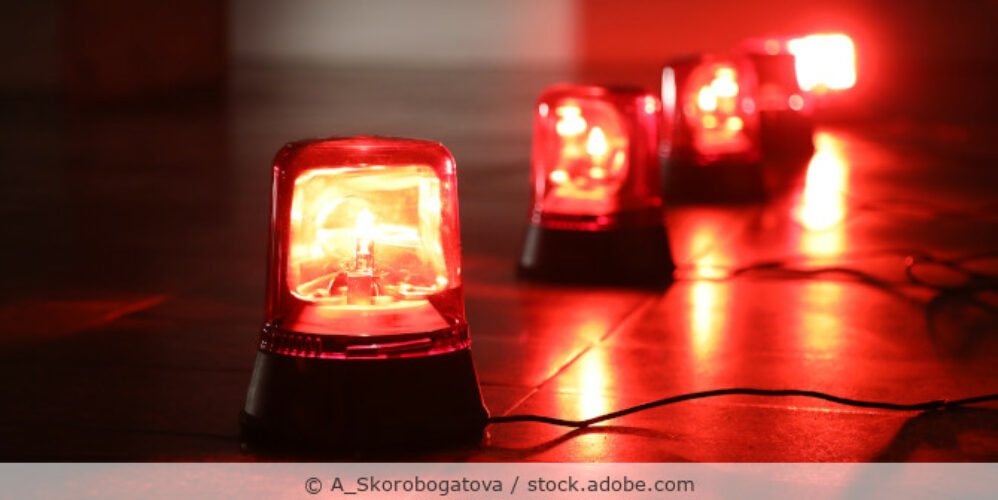Rote Alarmlichter stehen in einer Reihe auf dem Boden.