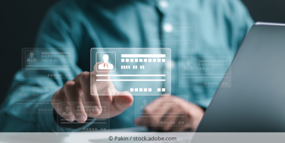 Person an Laptop wählt digitale Identität aus.