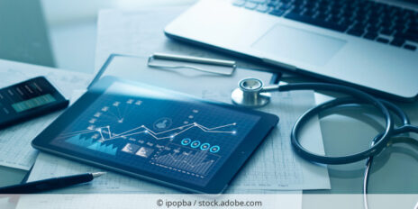 Tablet mit Gesundheitsdaten auf dem Schreibtisch neben einem Stetoskop.
