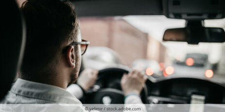 Rückansicht eines Autofahrers beim Lenken eines Fahrzeugs.
