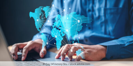Person working on laptop, world map symbolizes cross-border data tranfers./ Person arbeitet an Laptop, Weltkarte mit Punkten symbolisiert interanationale Datenflüsse.