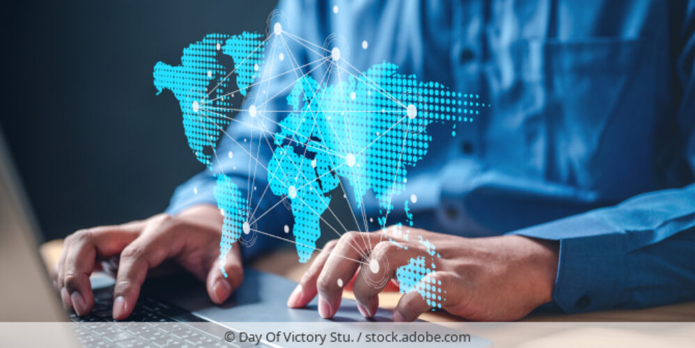 Person working on laptop, world map symbolizes cross-border data tranfers./ Person arbeitet an Laptop, Weltkarte mit Punkten symbolisiert interanationale Datenflüsse.