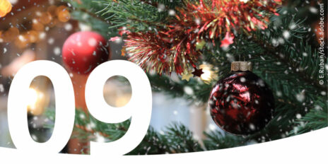 Nahaufnahme Christbaum mit roten Kugeln und im Vordergrund die Zahl 9.