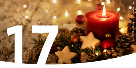 Weihnachtsgesteck mit einer brennenden Kerze und im Vordergrund die Zahl 17.