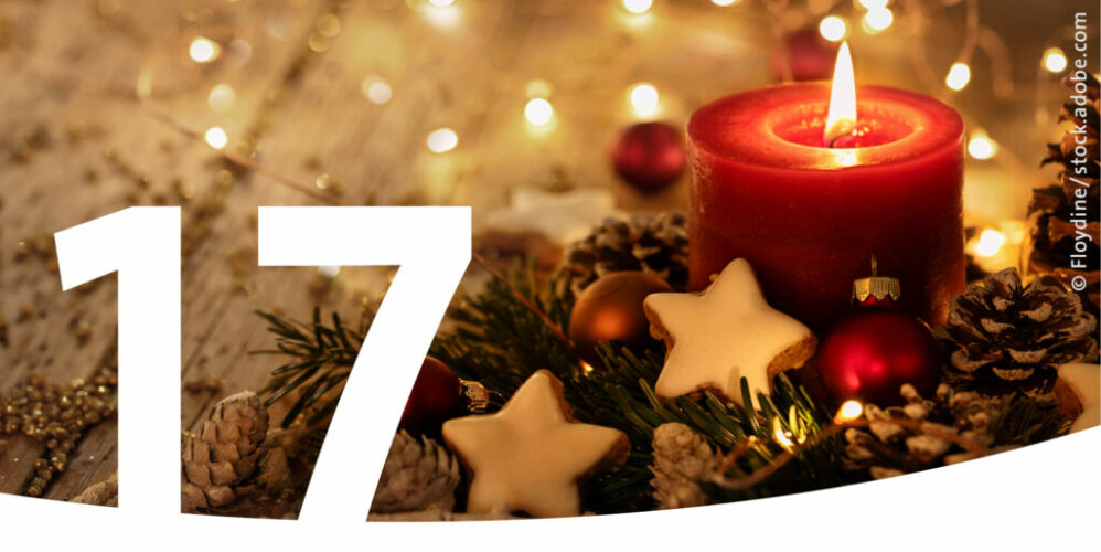 Weihnachtsgesteck mit einer brennenden Kerze und im Vordergrund die Zahl 17.