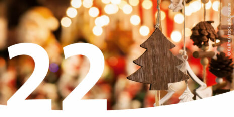 Hölzerner Weihnachtsbaumschmuck und im Vordergrund die Zahl 22.