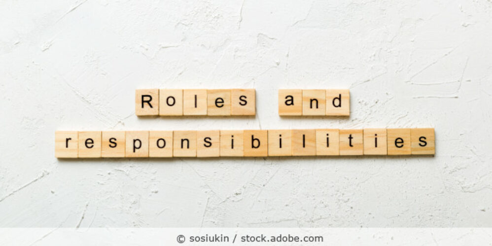 Holzbuchstabenkärtchen aus denen Roles and Resopnsibilities gelegt ist