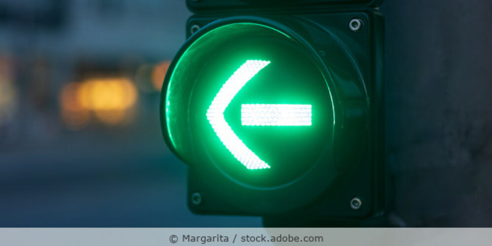 Grüner Pfeil für Abbieger an einer Ampel in der Nahaufnahme.