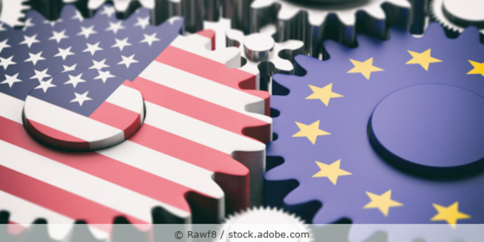 Illustration mit mehreren Zahnrädern, die ineinander greifen, zwei große Zahnräder mit der Flagge der USA und der EU.
