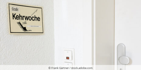 Ein Schild mit der Aufschrift "Große Kehrwoche" hängt neben einer Wohungstür.