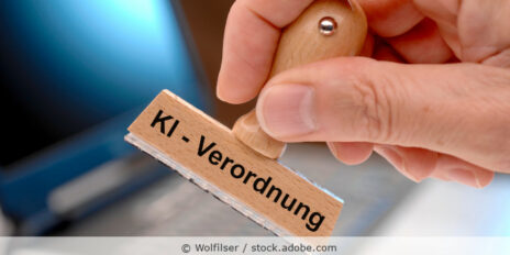 Ein Holzstempel ist beschriftet mit dem Aufdruck KI-Verordnung
