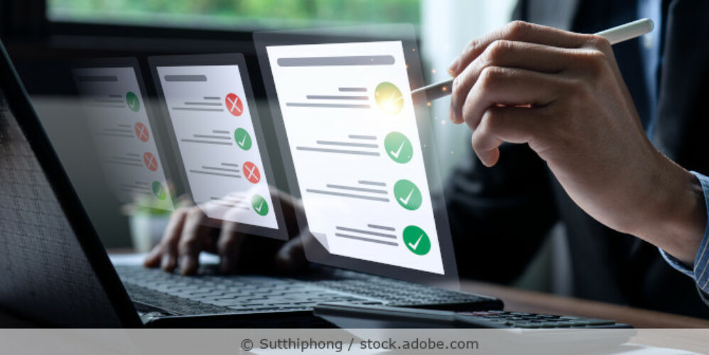 Checkliste, Geschäftsmann mit Laptop bei einer Online-Umfrage zur Checkliste, Ankreuzen auf der Checkliste und Ausfüllen eines Online-Formulars oder Beantworten von Fragen.