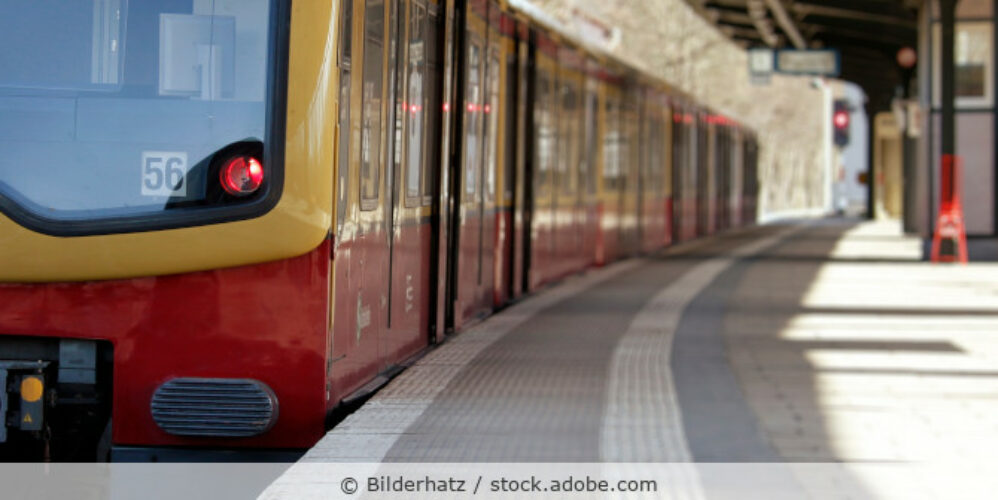 Eine rot-gelbe S-Bahn hält an einem Bahnsteig in Berlin.